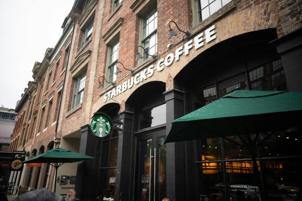 A Starbucks barista, Michael Harrison, was fired after he helped subdue two robbers who attacked him at his workplace in downtown St. Louis, per the NY Post.